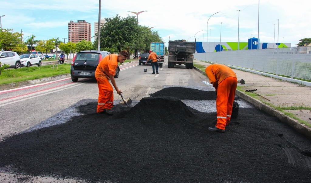 operários colocando asfalto numa via